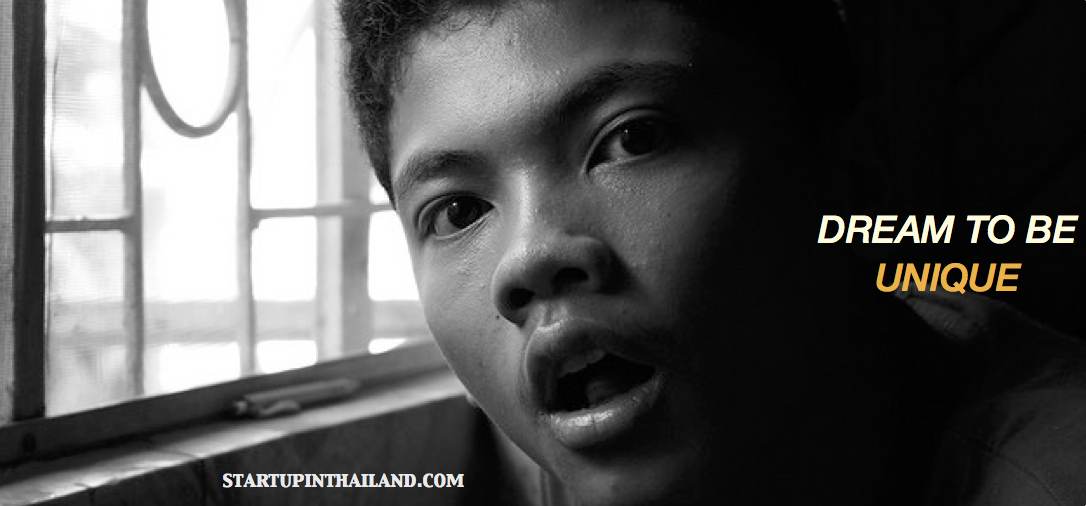 A close up shot of an Asian boy by the window with open mouth in black and white filter with caption 'Dream to be unique'