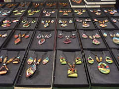 A display of handmade craft necklaces and earrings in different colors and designs